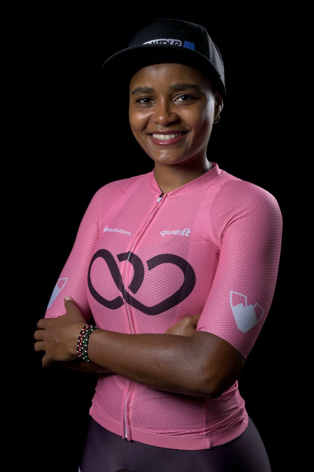 Iman Kagumba wearing a pink cycling jersey against a black background