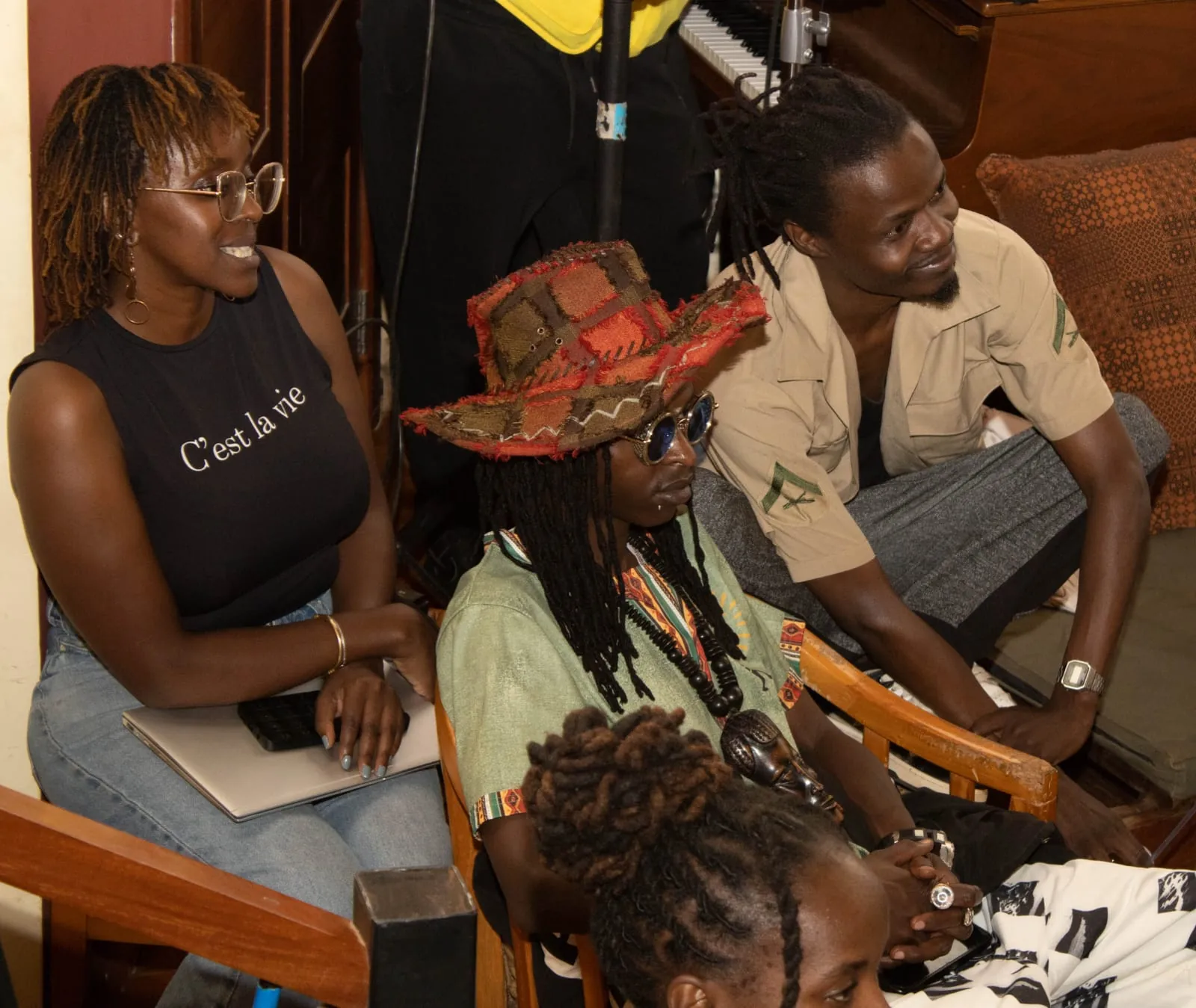 Four people seated close to a performance, watching and listening